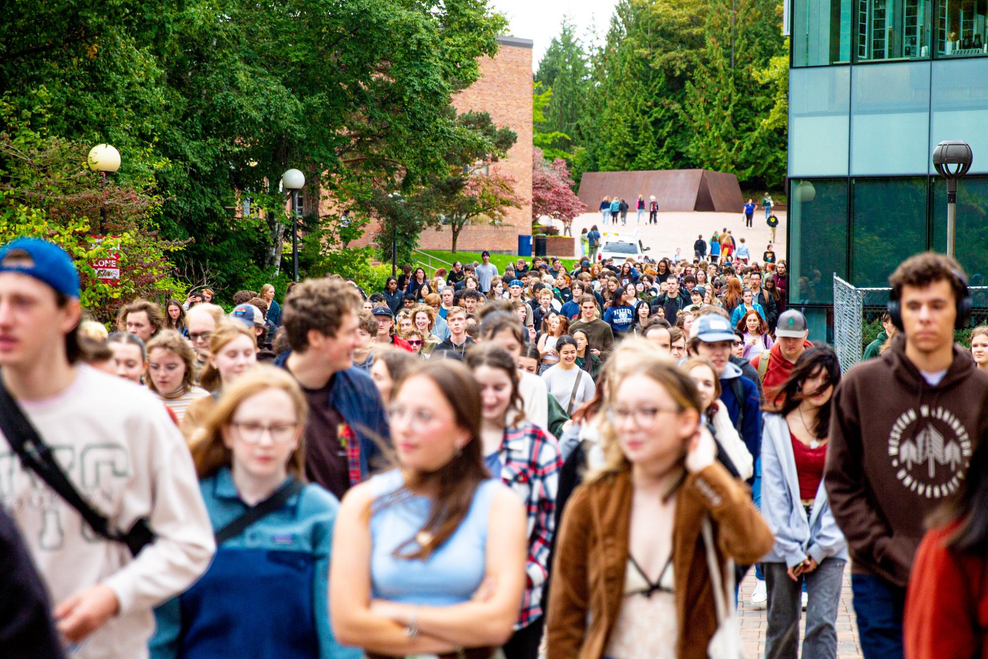 A large group of students walk on Western's campus. 