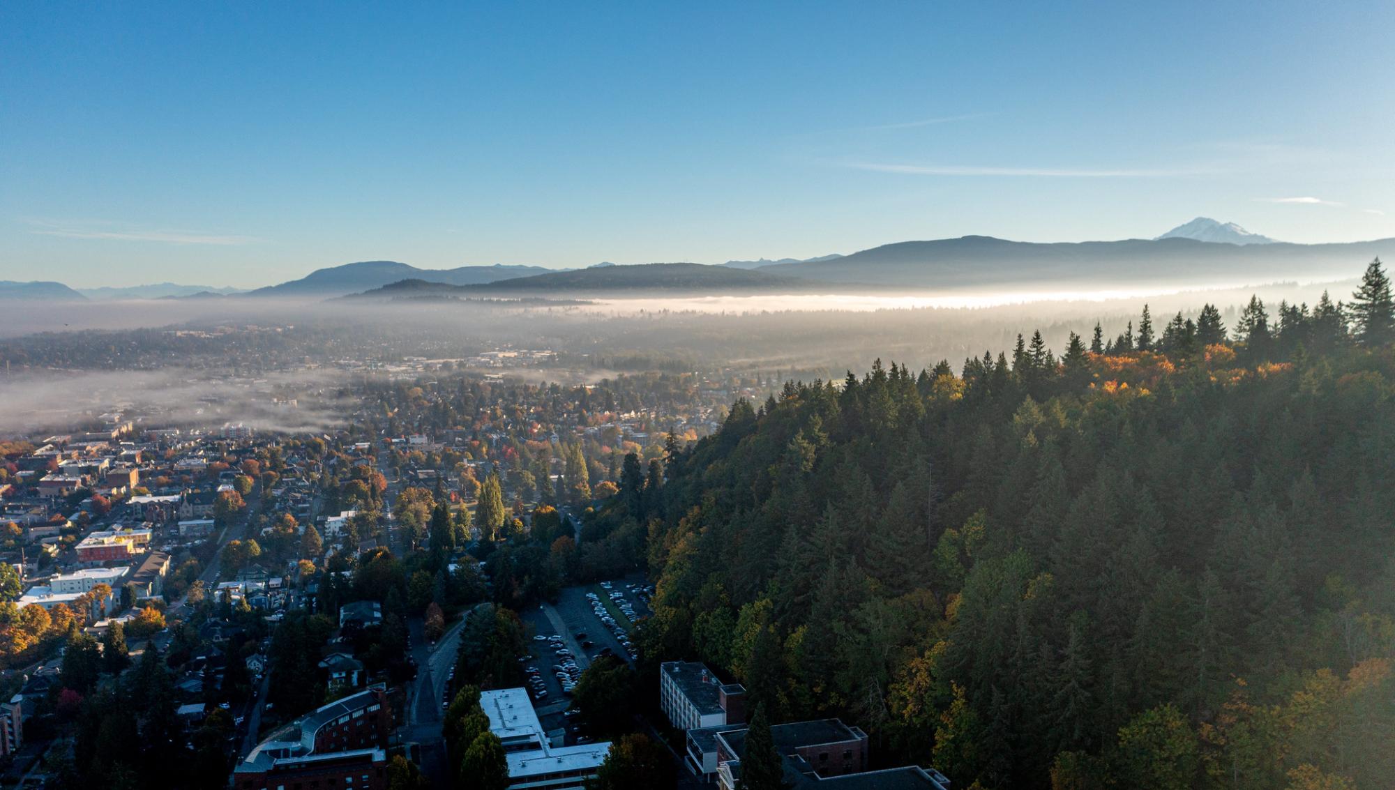 Mountains on the horizon are seen from Western's campus with a view of Bellingham from above. 